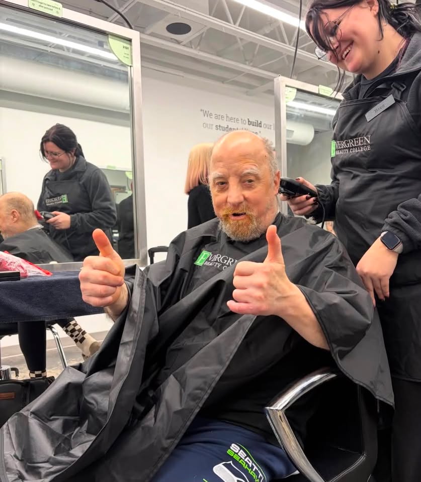 Kokua client Bryan giving a double thumbs-up during a haircut at Evergreen Beauty College